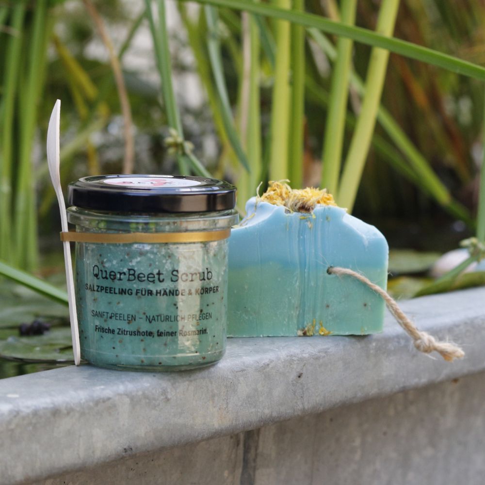 QuerBeet Salzpeeling und handgemachte Gartenseife mit Pflanzen im Hintergrund